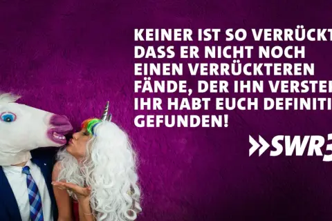 Ein Mann mit Einhornmaske küsst eine Frau mit Einhorn-Haarreif. Ein lustig-witziges Bild, das perfekt zum Hochzeitstag passt!