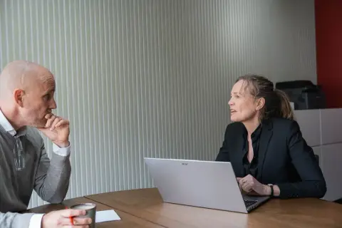 Man en vrouw in gesprek, oefenen gesprekstechnieken lastige mensen. De man denkt na, de vrouw legt uit.