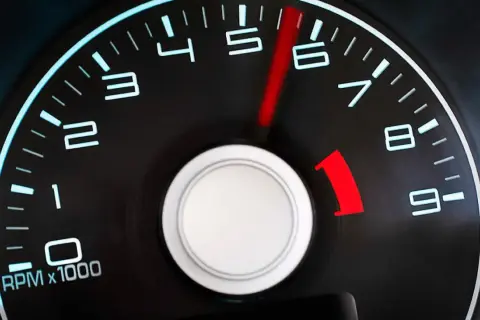 Tacómetro de un coche diésel mostrando altas revoluciones. La aguja roja apunta entre 5 y 6, indicando un motor acelerado.