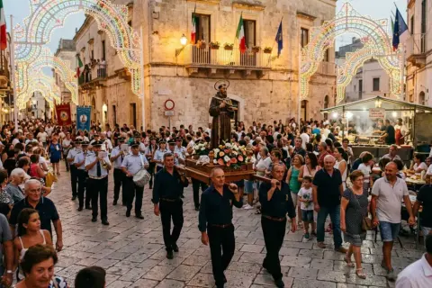 Processione religiosa con statua fiorita, musica e luminarie, un esempio di tradizioni popolari italiane per regione.