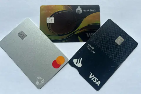 Trzy karty płatnicze: srebrna z logo Mastercard, czarna z logo Visa Credit Platinum i złota z logo Banku Polskiego.