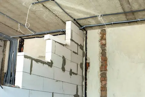 Ścianki działowe na poddaszu z bloczków gazobetonowych, z widocznym układem instalacji elektrycznej. Widać, jak wysoko murować ścianki działowe na poddaszu, by zapewnić miejsce na przewody.