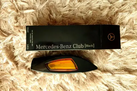 Elegancki flakon perfum Mercedes-Benz Club [Black] na puszystym tle.