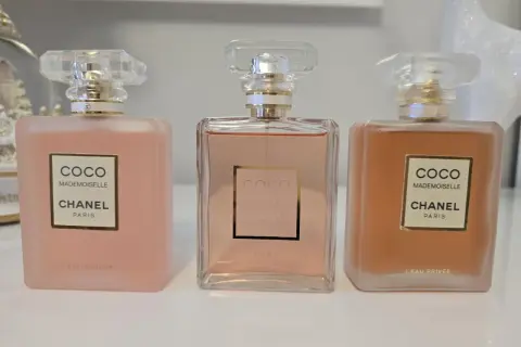 Trzy flakony Chanel Coco Mademoiselle L'Eau Privée w odcieniach różu i brzoskwini.
