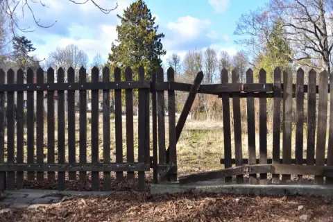 Drewniane ogrodzenie między sąsiadami, z otwartą furtką. Czy przepisy pozwalają na takie rozwiązania?