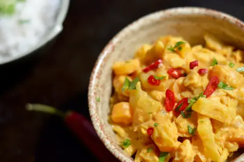 Curry z warzywami w kremowym sosie, posypane chili i natką. Szukasz, czym zastąpić mleczko kokosowe w curry?