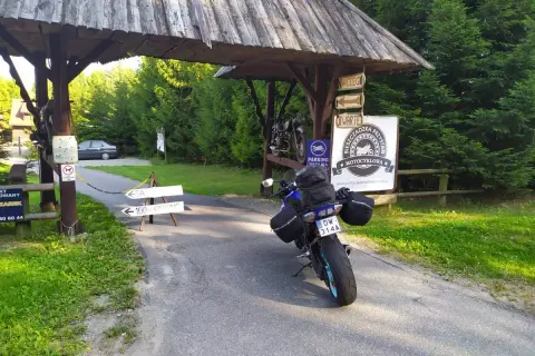 Motocykl czeka na dalszą podróż po Słowacji. Przy drogowskazie "100m parking" i znaku "Bieszczadzka Przystań Motocyklowa" zaczyna się przygoda.
