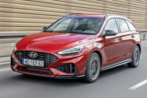 Czerwony Hyundai i30 N Line kombi w ruchu drogowym. Sportowy wygląd i dynamiczna jazda.