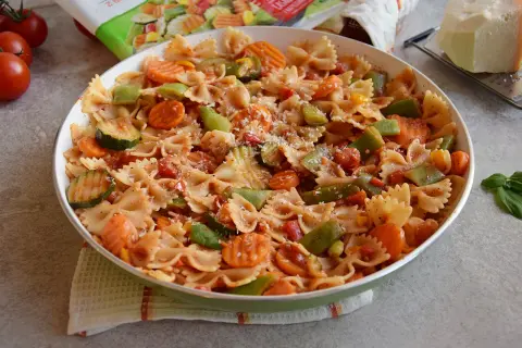 Pyszny makaron z warzywami na patelnię: farfalle z cukinią, marchewką i papryką w sosie pomidorowym.