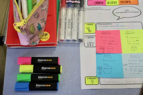 Materiales para escriptura creativa cicle inicial: rotuladores, libreta, lápices y notas adhesivas con ideas sobre deberes.