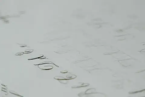 A page of practice calligraphy, with elegant loops and swirls in cursive, showing the careful strokes of a pen.