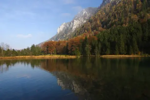 Herbstliche Farben am Falkensee Inzell, mit Bergen und Bäumen, die sich im ruhigen Wasser spiegeln.
