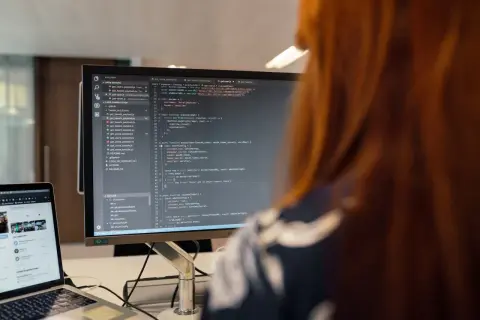Programista pracuje nad kodem, który może być kluczowy dla ustalenia, kto kontroluje legalność oprogramowania diagnostycznego w małych warsztatach.