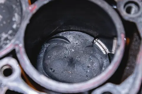Beschädigter Kolben in einem Motorzylinder. Solche Schäden können hohe **Kolbenfresser Kosten** verursachen.