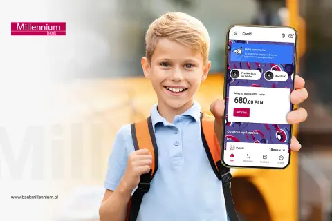 Uśmiechnięty chłopiec z plecakiem pokazuje telefon z aplikacją bankową. Na ekranie widnieje informacja o koncie dla dziecka Millennium 360° Junior z saldem 680 zł.