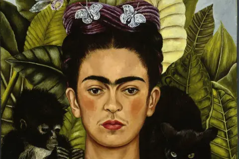 Frida Kahlo, con farfalle tra i capelli, circondata da foglie lussureggianti, un cerbiatto e un gatto nero. Queste immagini di Frida Kahlo sono iconiche.