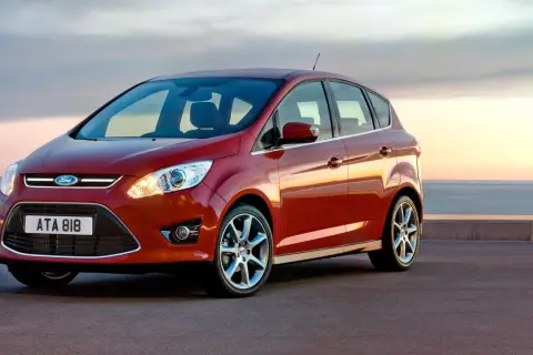 Röd Ford C-Max parkerad vid havet. Inga problem här, bara en vacker vy.