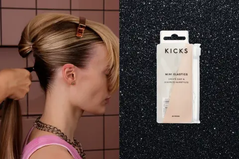 En person stylar ett elegant hårknut med en klämma. Bredvid syns en förpackning med Kicks mini-elastik för diskreta frisyrer.