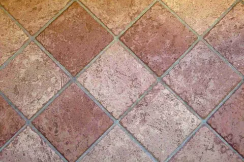 Carrelage mal posé, les carreaux de terre cuite sont de travers, créant un motif irrégulier et déroutant.