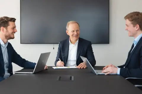 Fabian Bengtsson och kollegor i möte med laptops och anteckningsblock.