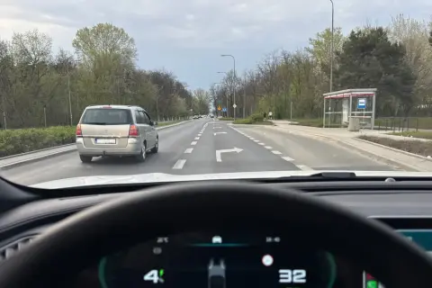 Jazda na suwak przepisy: samochód osobowy i minivan na drodze z pasami ruchu, jeden z nich wskazuje skręt w prawo.