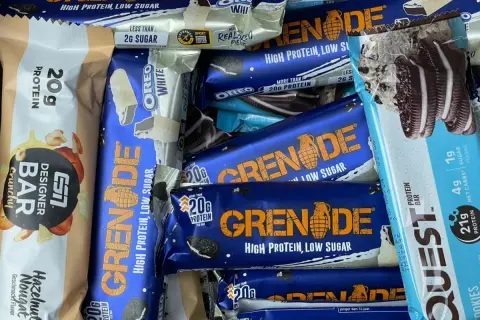 Ein bunter Haufen von Proteinriegeln, darunter Grenade und Quest. Ein Powerriegel-Test für Sportler.