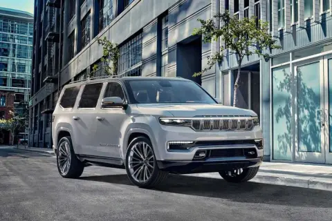 Elegancki, biały Wagoneer parkuje na miejskiej ulicy, obok nowoczesnych budynków.