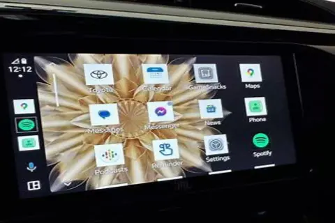 Ekran samochodu z interfejsem Android Auto. Widoczne ikony aplikacji: Toyota, Calendar, GameSnacks, Maps, Messenger, News, Phone, Spotify, Podcasts, Reminder, Settings.
