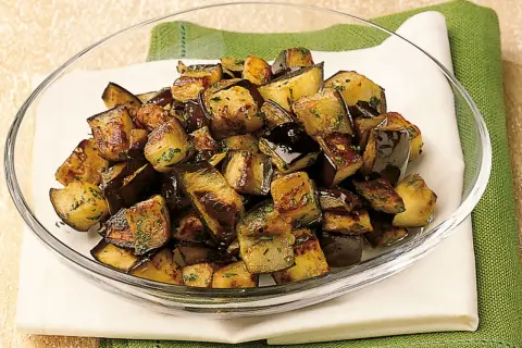 Melanzane a funghetto ricetta della nonna: cubetti dorati e saporiti, conditi con erbe aromatiche, pronti per essere gustati.