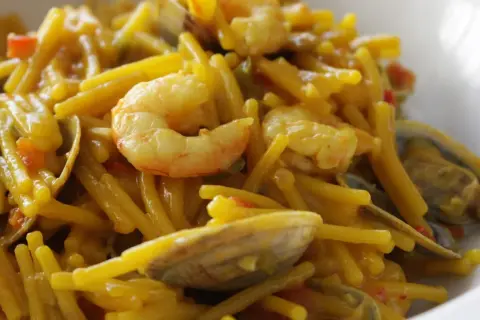 Fideos con almejas y gambas, un plato de marisco delicioso y lleno de sabor.