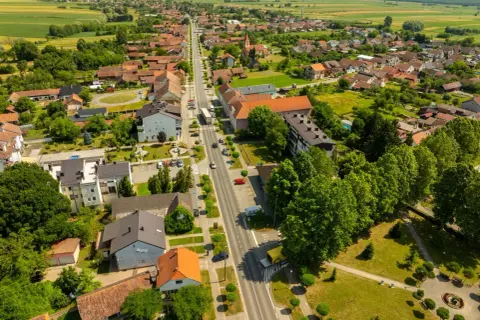 Widok z lotu ptaka na spokojne miasteczko, gdzie zielone pola przeplatają się z dachami domów. Odkryj urokliwe śrem atrakcje i poczuj atmosferę sielskiego życia.