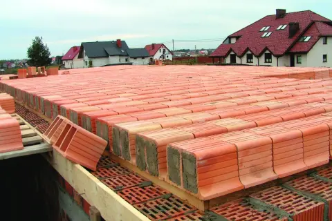 Budowa stropu Akermana z pustaków ceramicznych. Widać rzędy pustaków przygotowanych do ułożenia, tworzące solidną konstrukcję.