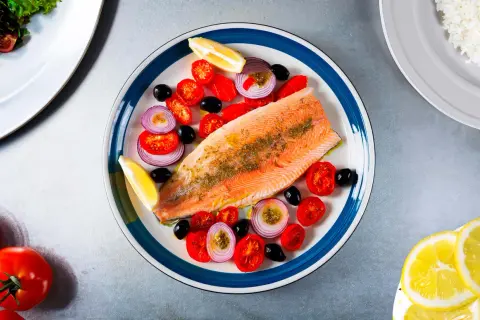 Une belle recette de truite avec tomates cerises, olives noires, oignons rouges et quartiers de citron. Un plat savoureux et coloré.
