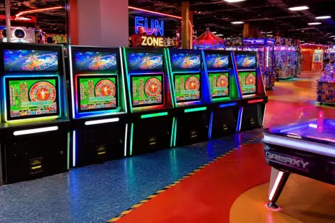 Rząd podświetlanych maszyn do gry zręcznościowej w "Fun Zone", gdzie każdy może spróbować szczęścia.