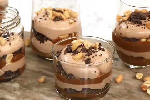Chokladmousse-desserter i glas med lager av choklad, kolasås och jordnötter. En härlig rocky road-upplevelse!