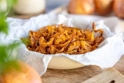 Knusprig gebratene Zwiebelringe in einer Schüssel, bereit zum Genießen. Perfekt, um Gerichte zu verfeinern.