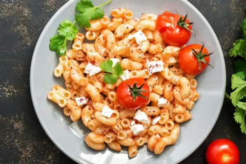 Feta Pasta aus dem Ofen: cremige Makkaroni mit geschmolzenem Feta, Kirschtomaten und frischer Petersilie.