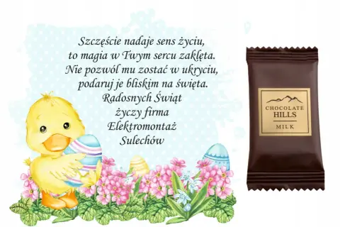 Uroczy kurczaczek z pisankami i kwiatami, obok czekoladka "Chocolate Hills". Wesołych Świąt życzy firma Elektromontaż Sulechów.