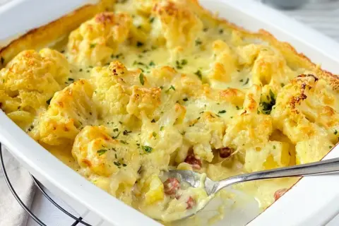 Ein cremiger Blumenkohl Kartoffel Auflauf mit Käse überbacken, garniert mit Petersilie. Perfekt für ein herzhaftes Abendessen.