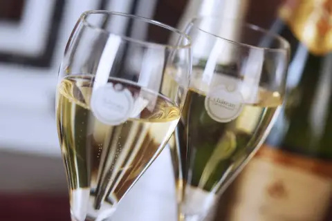 Zwei Gläser mit Champagner, die verschiedene Champagner-Sorten repräsentieren. Bläschen steigen auf.