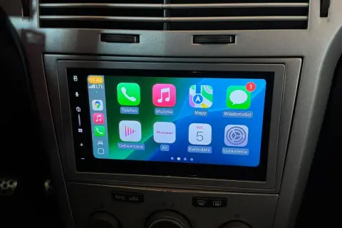 Nowe radio Android w Oplu Astra H z ekranem dotykowym i ikonami aplikacji: Telefon, Muzyka, Mapy, Wiadomości, Odtwarzane, AV, Kalendarz, Ustawienia.