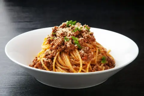 Spaghetti bolognese, prosty przepis. Aromatyczny sos mięsny na złocistym makaronie, posypany parmezanem i natką pietruszki.