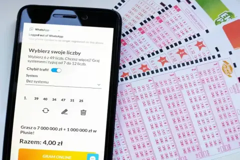 Telefon z aplikacją do gry w Lotto obok kuponów. Dowiedz się, jak zrezygnować z automatycznego odnawiania subskrypcji lotto online.