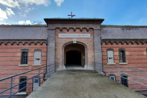 Fort Poznań, dawniej obóz koncentracyjny, z charakterystycznym łukiem i napisem.