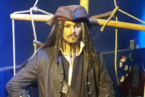 Kapitan Jack Sparrow w muzeum figur woskowych Władysławowo. Pirat w charakterystycznym stroju i kapeluszu, otoczony linami statku.