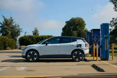 Voiture électrique blanche branchée à une borne de recharge. Un avantage véhicule électrique : l'énergie propre pour un avenir durable.