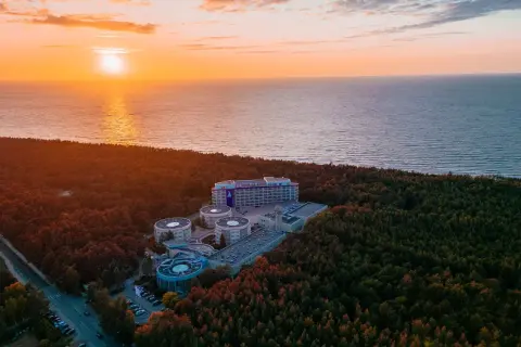Zachód słońca nad morzem, otaczający las i kompleks hotelowy Hotel Senator Dźwirzyno.