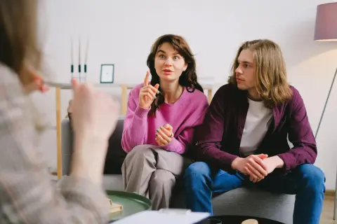 Para omawia problemy w związku, kobieta gestykuluje, mężczyzna słucha.