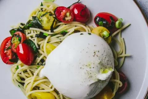 Une burrata crémeuse sur des pâtes aux tomates cerises et basilic. Une recette simple et savoureuse.
