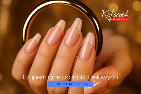 Dłoń z idealnymi paznokciami żelowymi, gotowymi na uzupełnienie. Złoty pierścień dodaje elegancji.